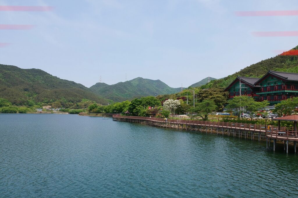 저수지 수면에 가까운 저공에서 저수지를 바라보는 사진. 위쪽 양 귀퉁이에 빨간 선 몇 가닥이 그어져 있다.