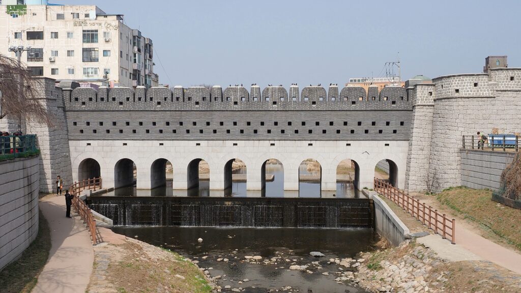 수원 화성의 남수문. 아래 수원천이 흐르고 9개의 아치 구조로 된 석조 구조물이 그 위에 놓여 있다.