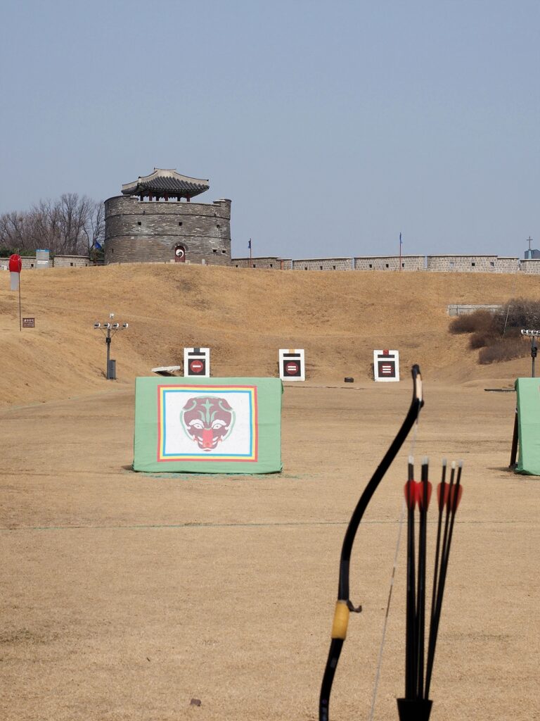 수원 화성 연무대의 국궁체험 시설. 사대에서 과녁을 바라본 모습이다. 뒤로는 공심돈이 서 있다.