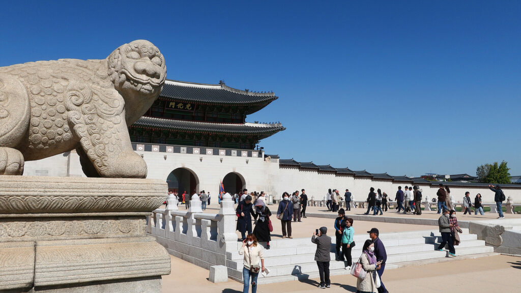 월대가 복원된 서울 광화문과 해치상. 많은 관람객이 지나고 있고, 위쪽으로는 푸른 하늘이 펼쳐져 있다.