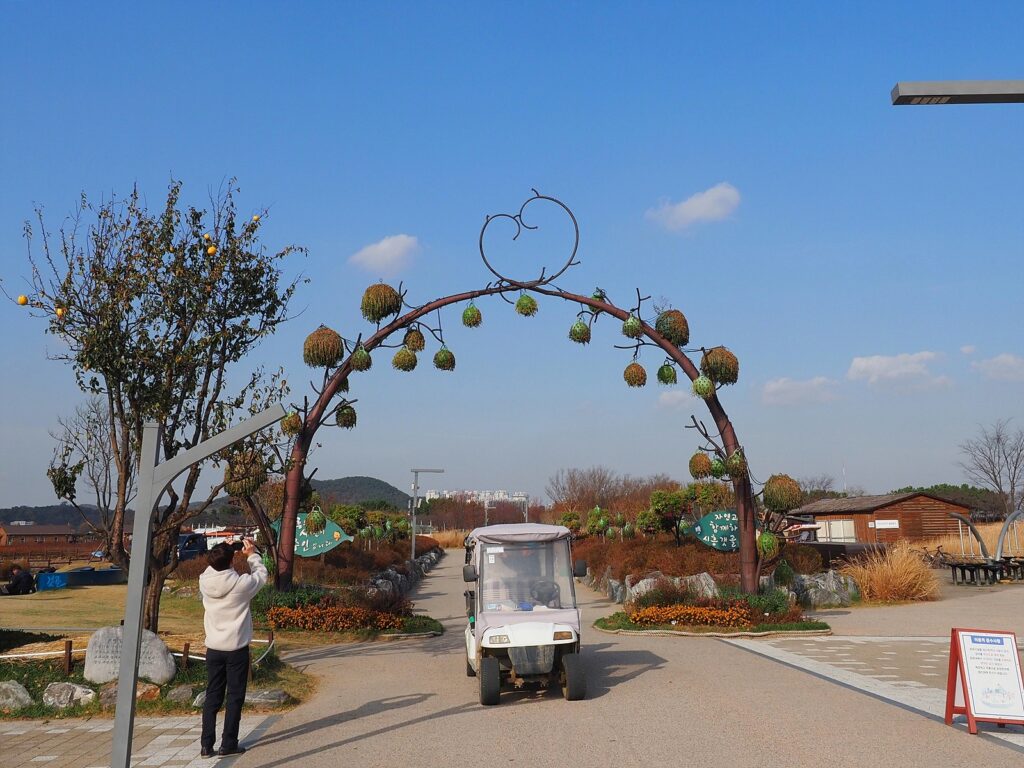 경기 시흥 갯골생태공원 입구. 파란 하늘을 배경으로 하트 모양의 조형물이 얹어진 문이 서 있다.