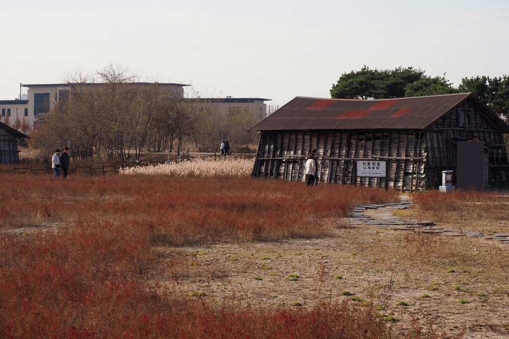 낡은 소금창고 앞으로 방문객들이 지나가고 있다.