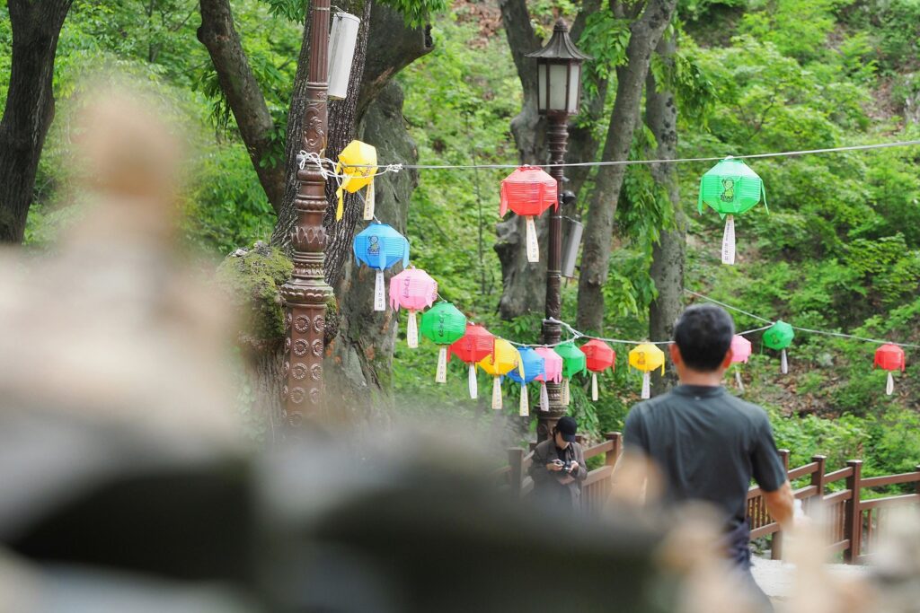 연등이 나란히 매달려 있는 등산로를 등산객들이 지나가고 있다.