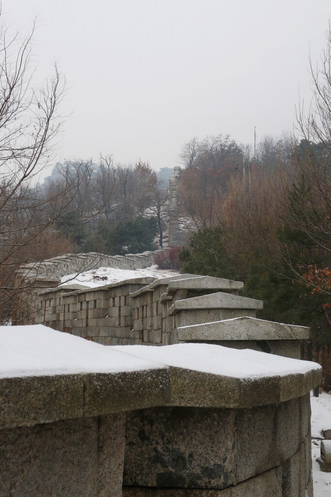 한양도성 성벽이 위쪽으로 뻗어 있다. 눈이 살짝 덮였다.