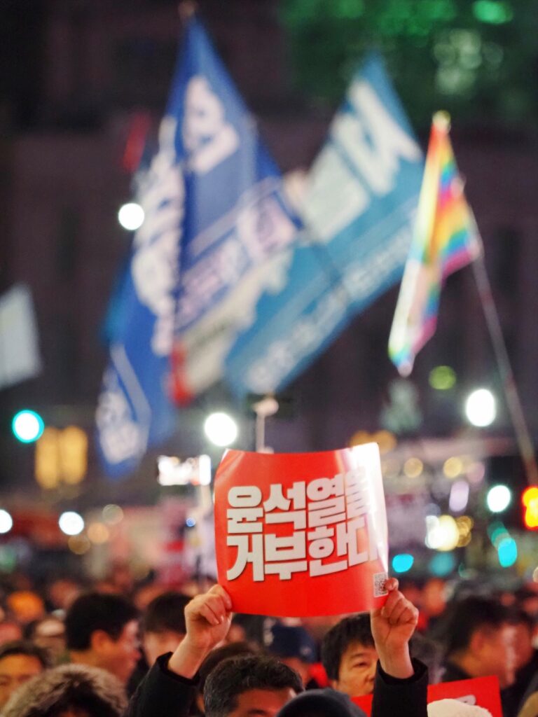 "윤석열을 거부한다"라고 적힌 팻말을 들고 행진하는 시민.