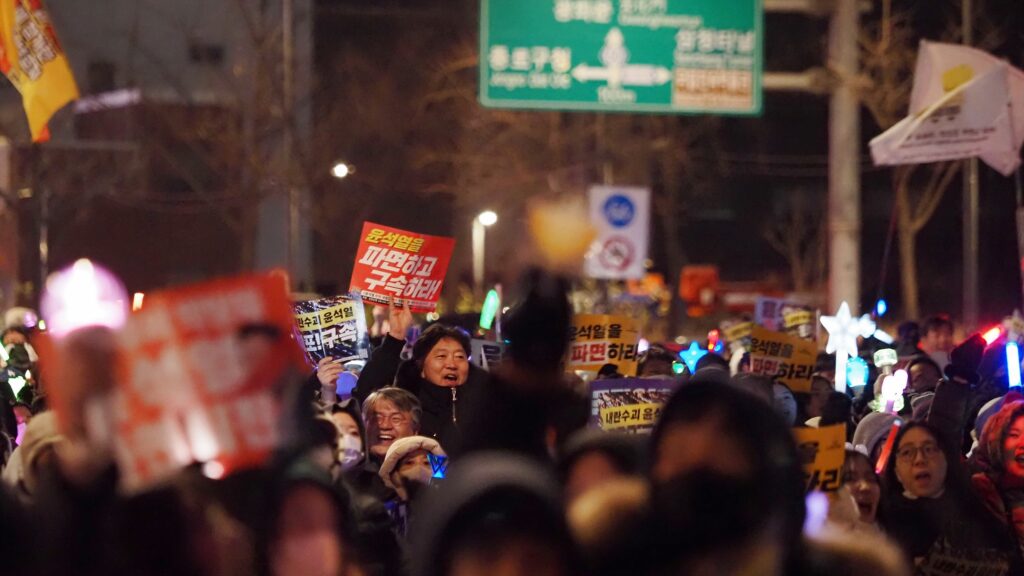 피켓과 응원봉을 들고 행진하는 시민들.
