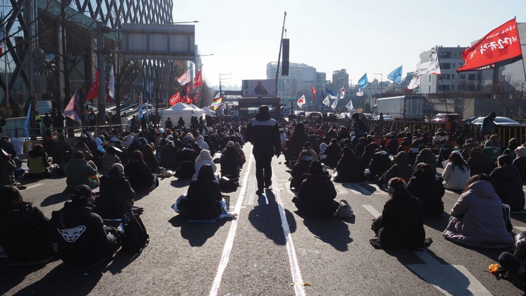 시민들 사이로 민주노총 조합원이 앞으로 걸어가고 있다.