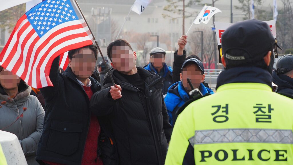 성조기를 든 사람들이 몰려와 집회를 방해하는 모습. 얼굴은 모자이크 처리.