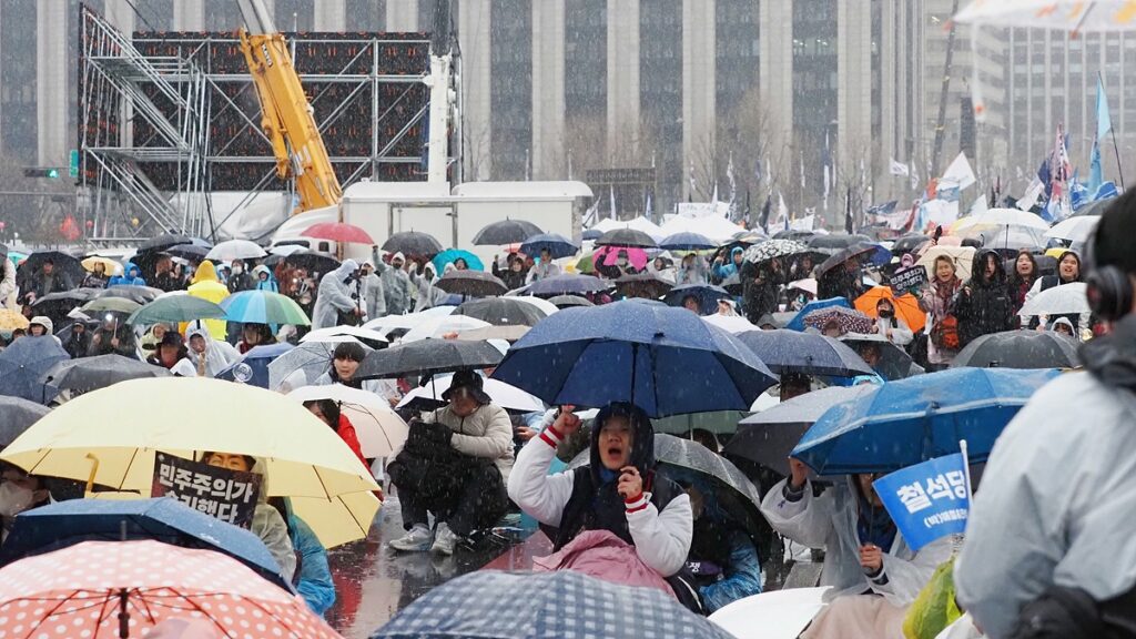 우산을 든 채 자리를 지키는 시민들.